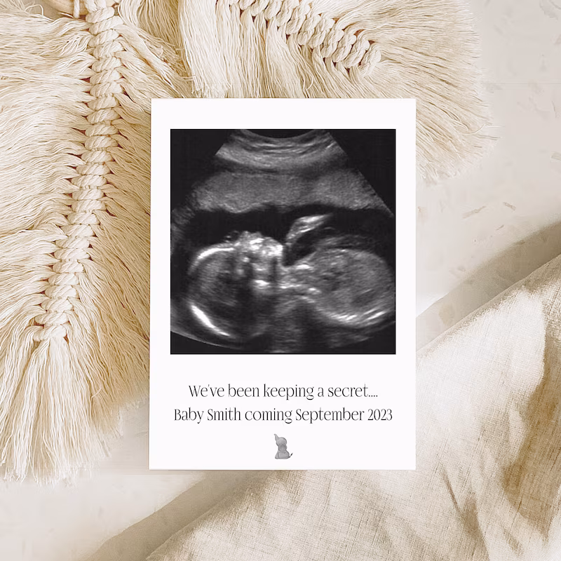 Baby ultrasound announcement card with neutral fabric background