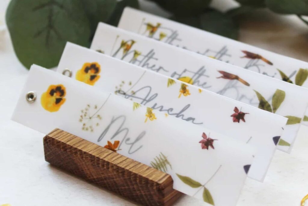 Stack of personalised name place cards with floral details on table
