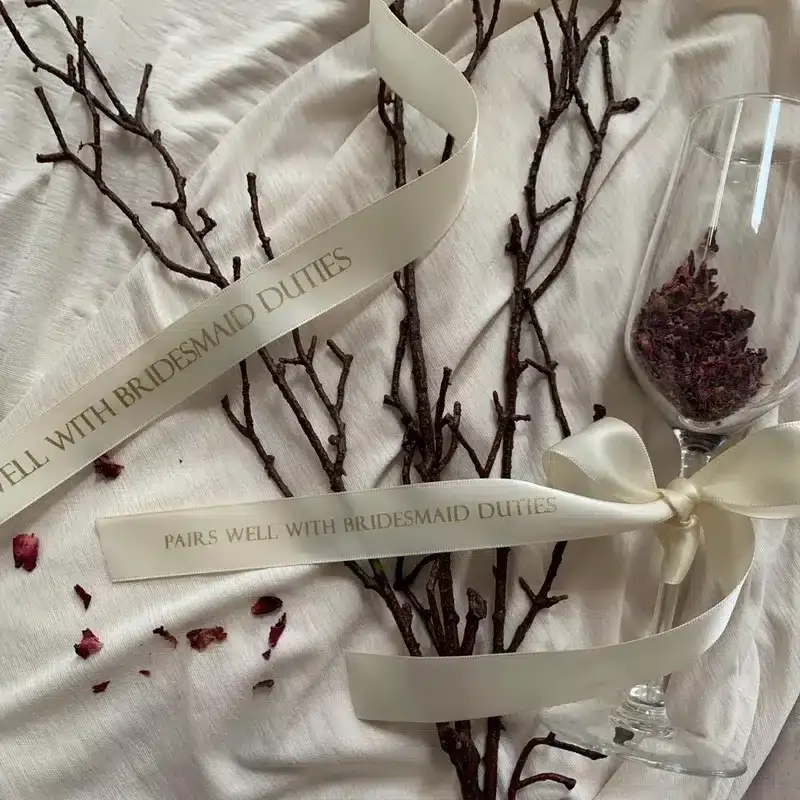 Luxury Wedding Invitations & Stationery styled with silk ribbon, glass detail and dried florals on neutral fabric background